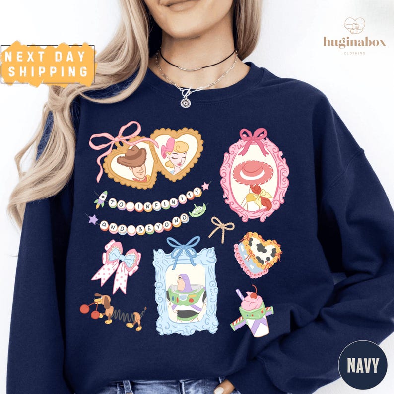 A woman wearing a navy blue sweatshirt with various cartoon-style illustrations and text on it.