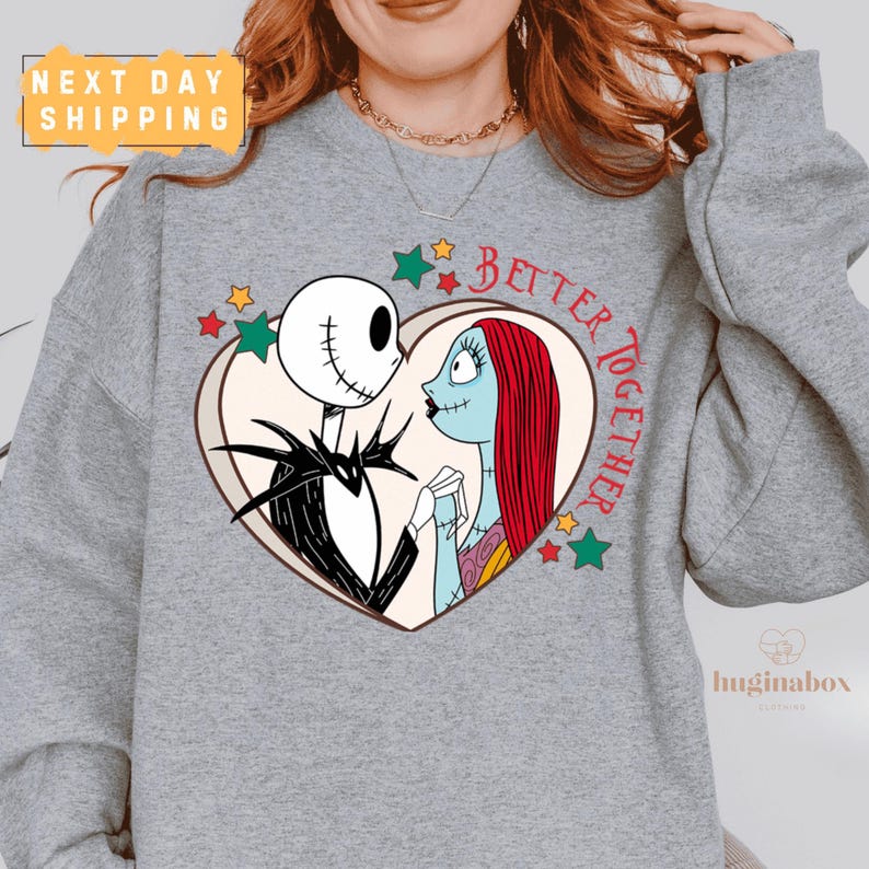 A gray sweatshirt with a graphic design featuring a skeleton and a woman with red hair, surrounded by stars and the text "Better together".