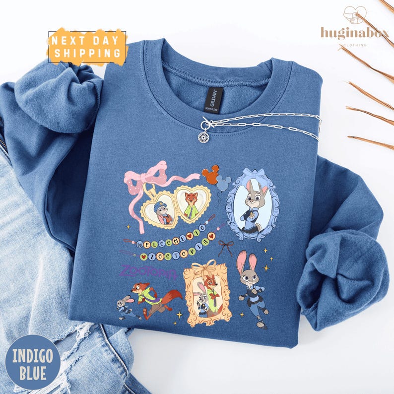 A blue sweatshirt with various cartoon animal characters and a heart-shaped design, along with a necklace and a chain.