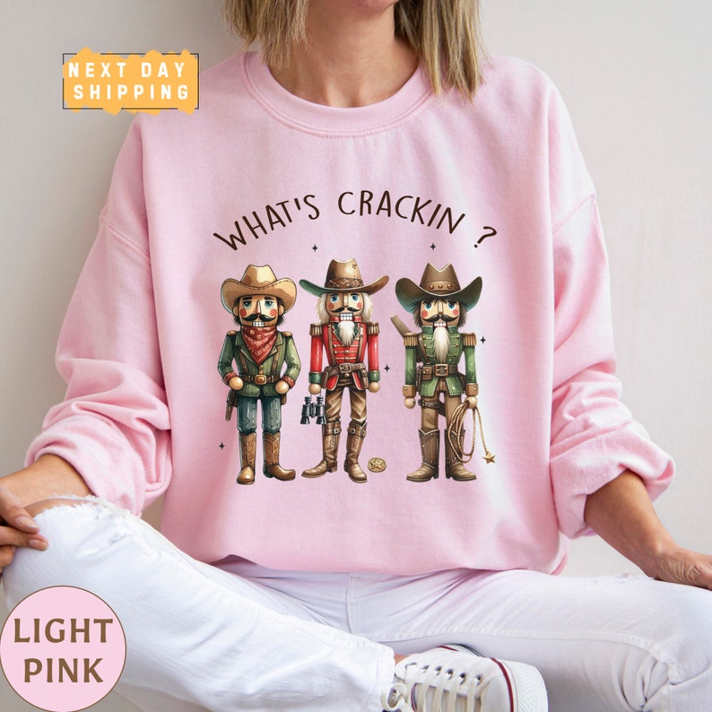 a woman wearing a pink shirt with three cowboys on it