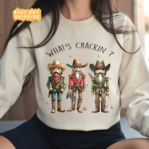 a woman wearing a sweater that says what's crackin?