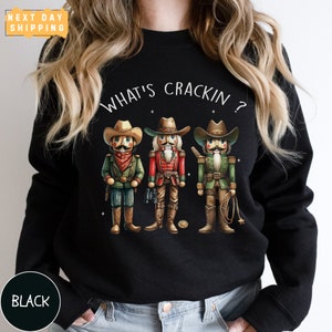 a woman wearing a black sweater with three cartoon characters on it