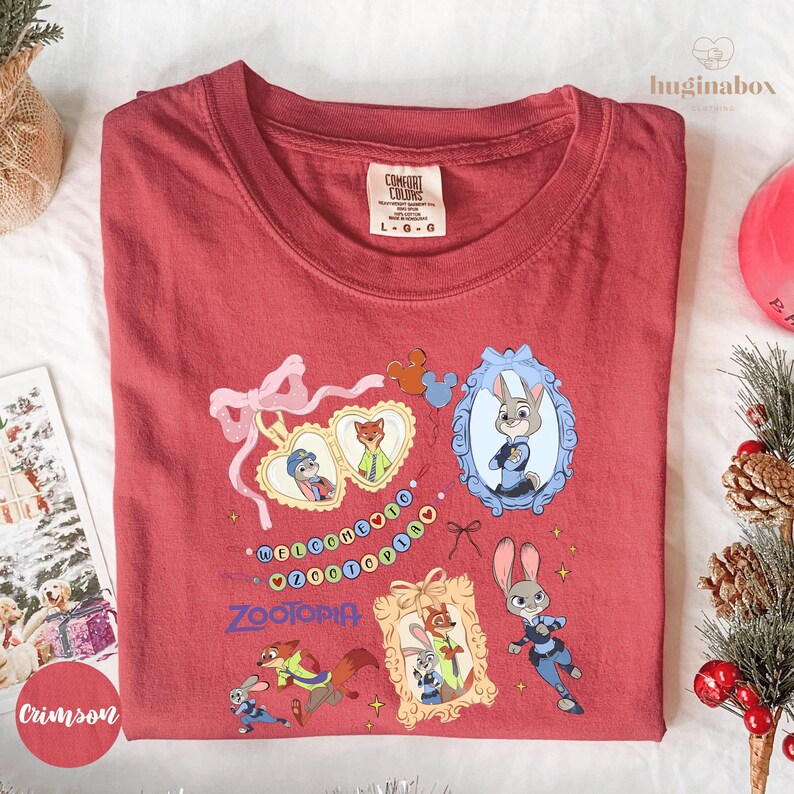 a red t-shirt with various cartoon animal characters and a bow, along with some holiday decorations such as pine cones and berries.