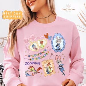 A woman wearing a pink sweatshirt with various cartoon animal characters and designs printed on it.