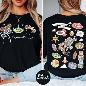 a woman wearing a black t-shirt with various cartoon characters and designs printed on it.