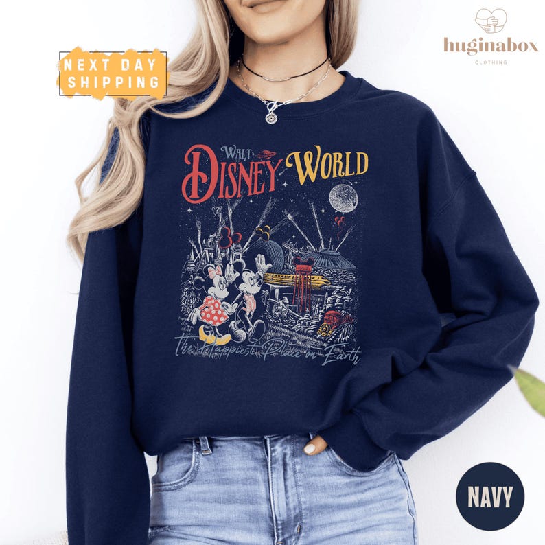 A woman wearing a navy blue sweatshirt with a Disney World-themed graphic printed on it.