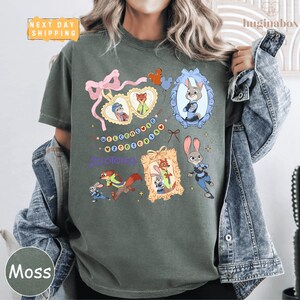 A person wearing a green t-shirt with various cartoon animal characters and a pink bow, along with a denim jacket.