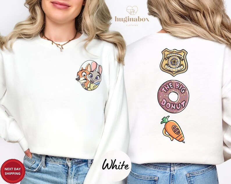 A woman wearing a white sweater with cartoon characters and a donut on the back.