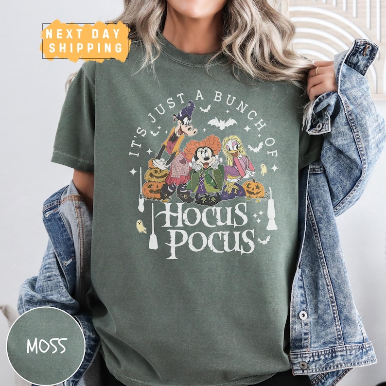 a woman wearing a green t - shirt with the words hocus pocus on