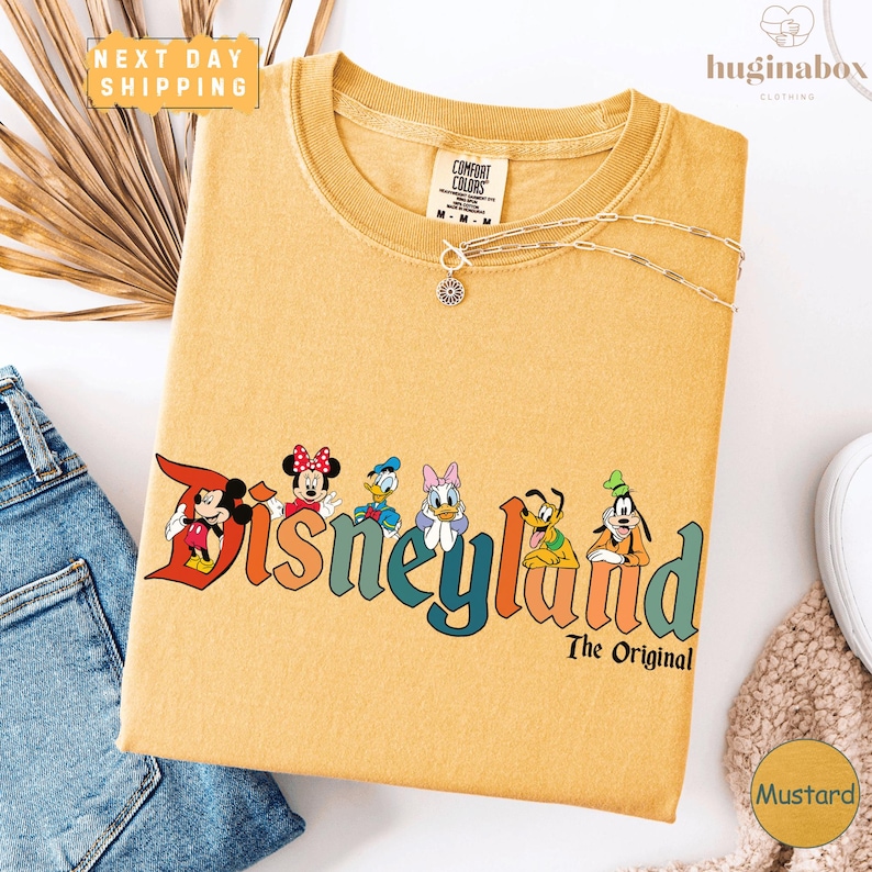 a yellow t-shirt with a Disney logo and text, along with a denim shirt and some decorative elements like a palm frond and a necklace.