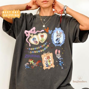 A person wearing a black t-shirt with various cartoon animal characters and a heart-shaped ribbon design.