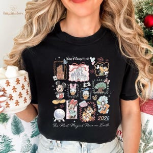 A woman wearing a black t-shirt with a collage of Disney characters and a mug of hot chocolate.