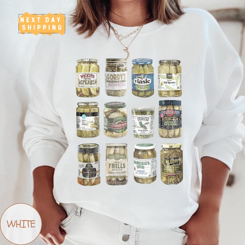 a woman wearing a white shirt with a bunch of pickles on it