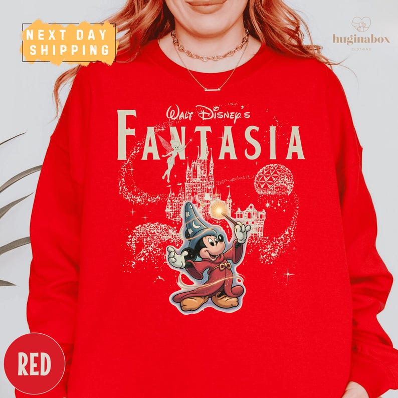 A person wearing a red sweater with a Disney-themed design featuring Mickey Mouse and the title "Fantasia".