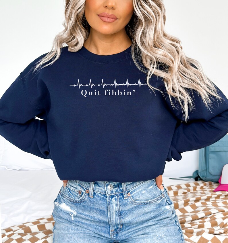 a woman with blonde hair wearing a sweatshirt and jeans