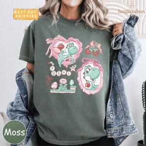 A person wearing a green t-shirt with a graphic design featuring a character from the Mario video game franchise.