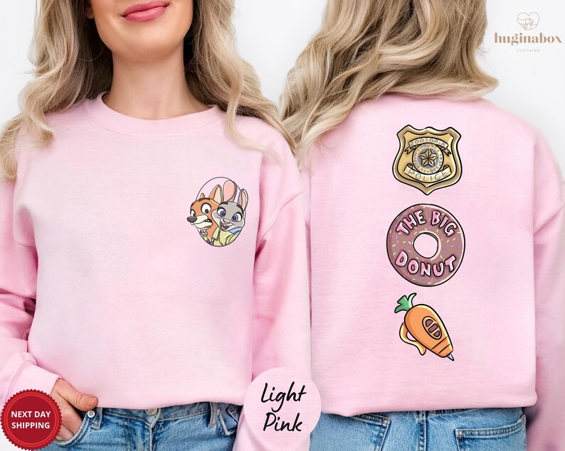 A woman wearing a pink sweatshirt with cartoon characters and a donut on the back.