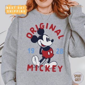 A gray sweatshirt with a graphic of Mickey Mouse and the text "ORIGINAL MICKEY" printed on it.