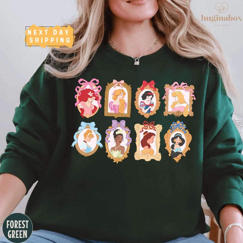 A woman wearing a green sweater with a collage of Disney princess portraits on it.