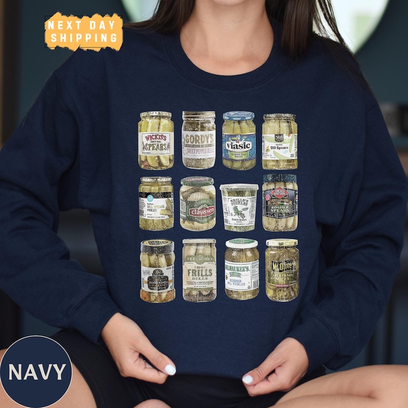 a woman wearing a navy blue shirt with a picture of jars of pickles on