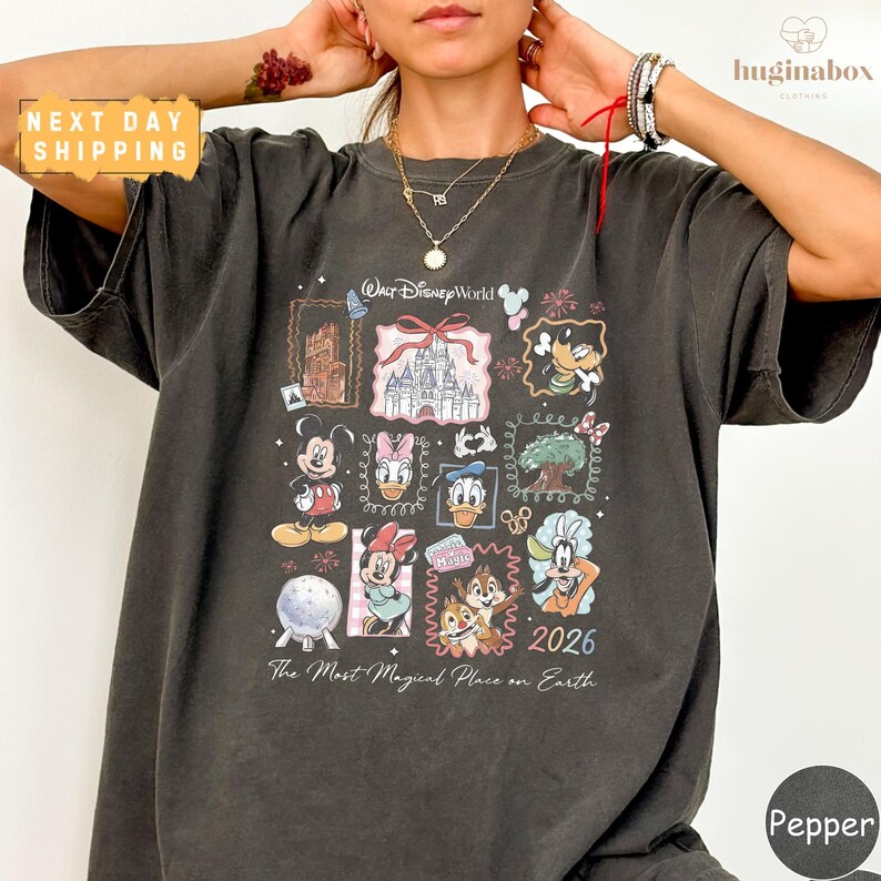 A person wearing a black t-shirt with a graphic design featuring various Disney characters and the text "The Most Magical Place on Earth" printed on it.