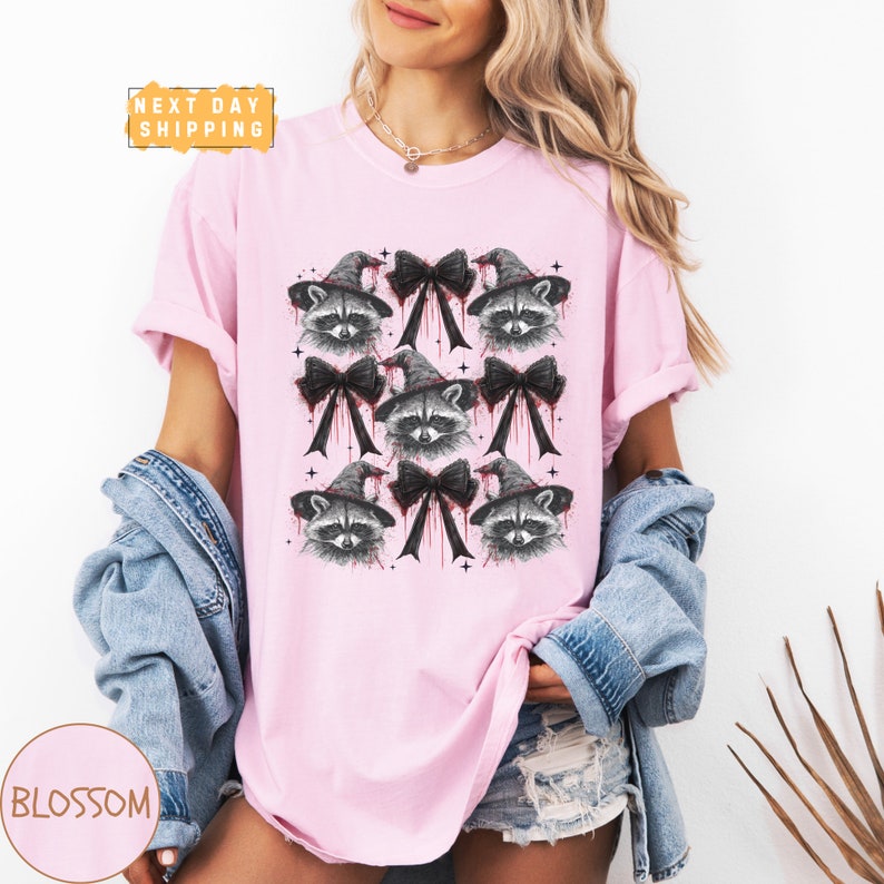 a woman wearing a pink shirt with a raccoon on it