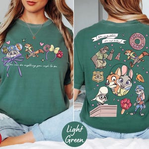 A woman wearing a green t-shirt with a cartoon character design on the front and the back.
