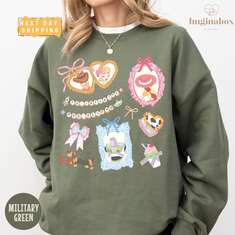 A person wearing a green sweatshirt with various cartoon-style illustrations and text on it.