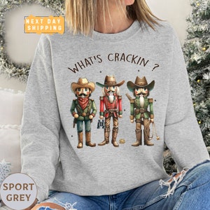 a woman wearing a sweatshirt that says what's crackin?