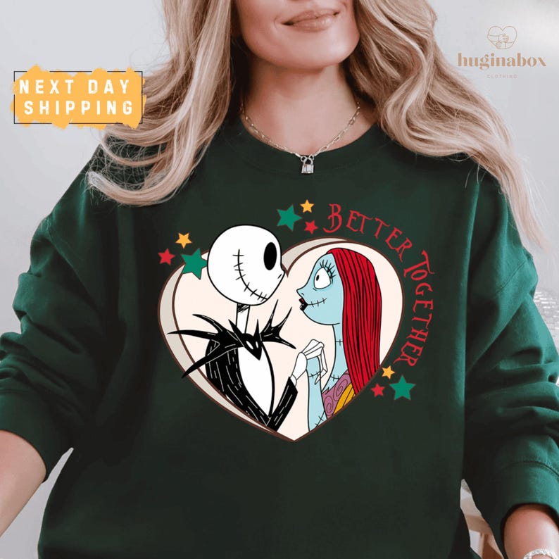 A woman wearing a green sweatshirt with a graphic design featuring the characters Jack Skellington and Sally from the movie " jack Skellington and Sally".