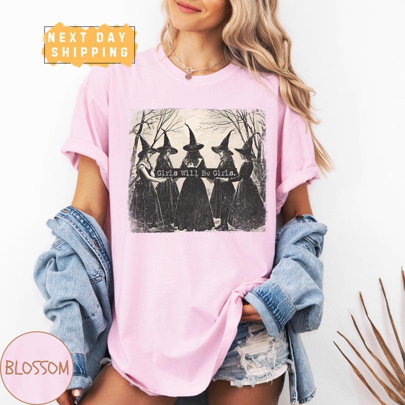 a woman wearing a pink shirt with witches on it