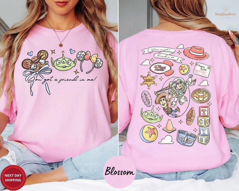 A woman wearing a pink t-shirt with various cartoon characters and icons printed on it, including a character from the Toy Story franchise.
