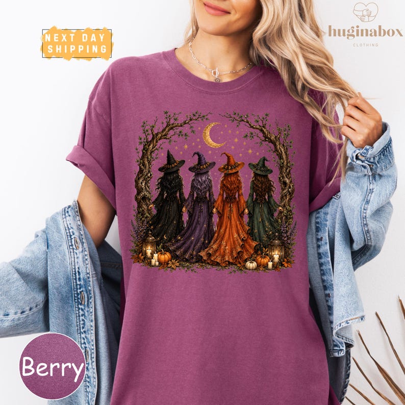 A woman wearing a purple t-shirt with a graphic design of four witch characters in a forest setting.