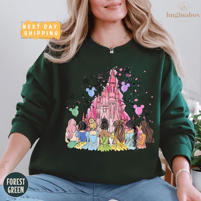 A woman wearing a green sweater with a colorful illustration of Disney princesses and a castle on it.