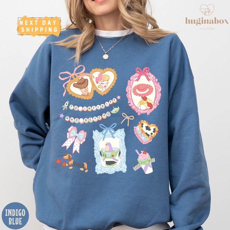 A woman wearing a blue sweatshirt with various cartoon-style illustrations and text on it.
