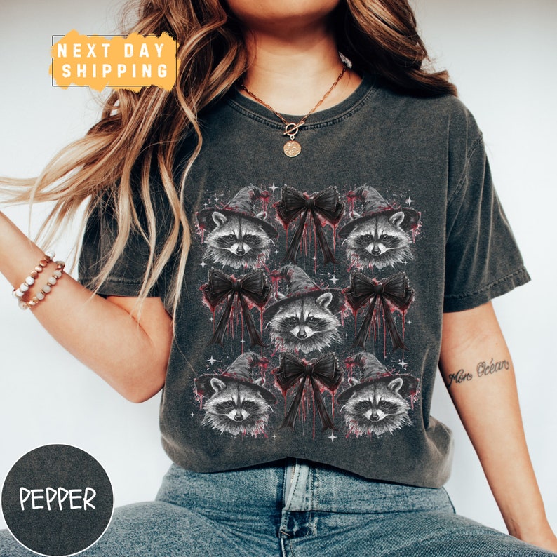 a woman wearing a shirt with raccoons on it