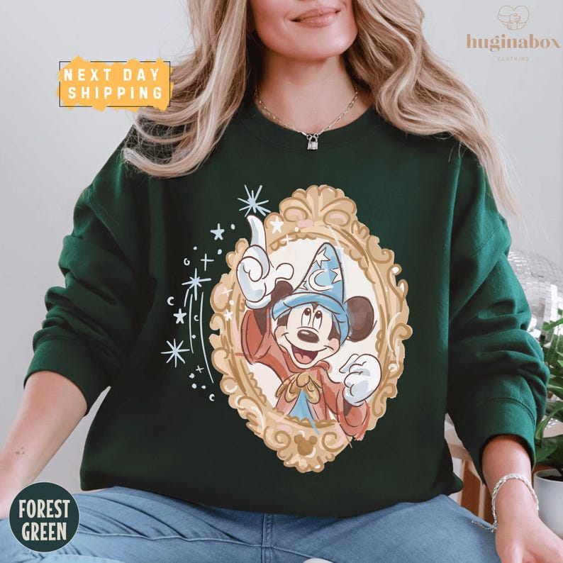 A woman wearing a green sweater with a graphic of Mickey Mouse and a frame design.