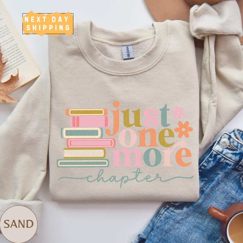 a sweater that says just one more, next to a cup of coffee and a