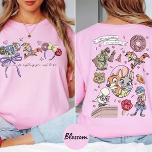 A woman wearing a pink t-shirt with a cartoon character design on the front and a back view of the same design.