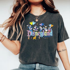 a woman with long hair wearing a disneyland shirt