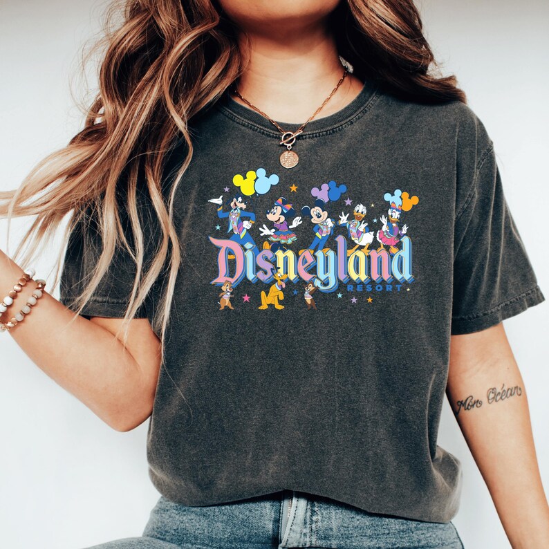 a woman with long hair wearing a disneyland shirt