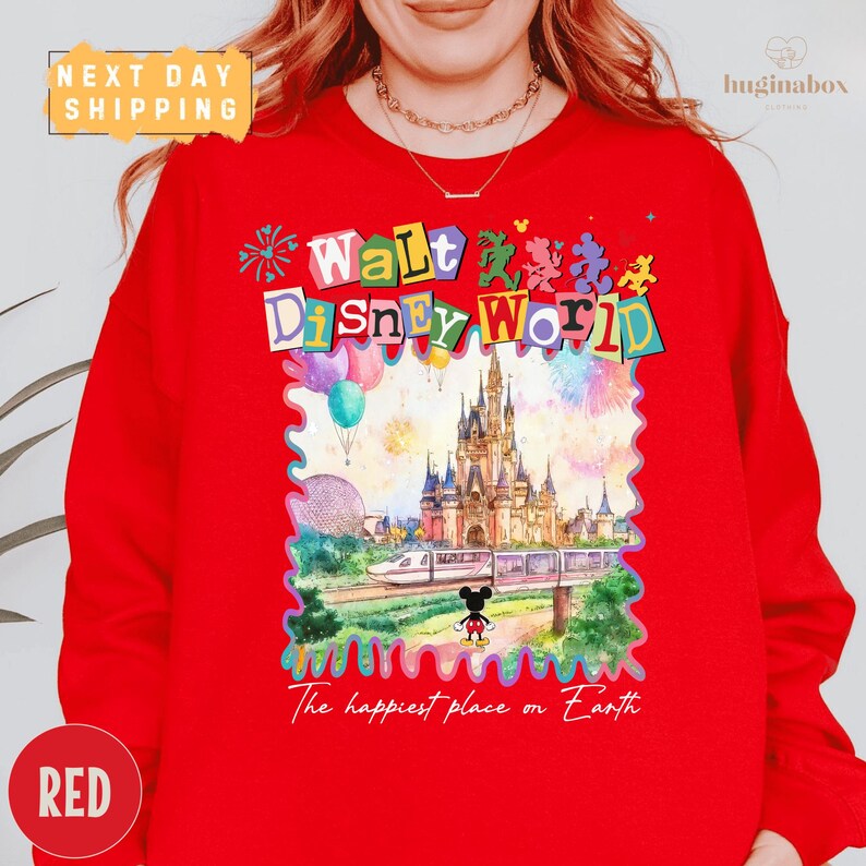 A person wearing a red sweater with a colorful, whimsical design depicting a Disney World castle and various Disney characters.