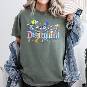 a woman wearing a disneyland shirt and denim jacket