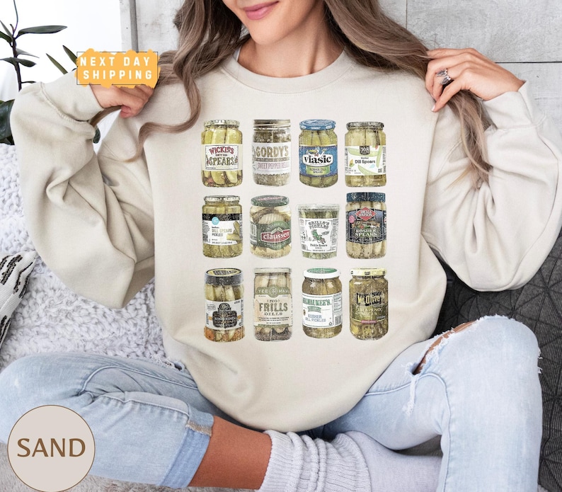 a woman sitting on a couch holding a jar of pickles