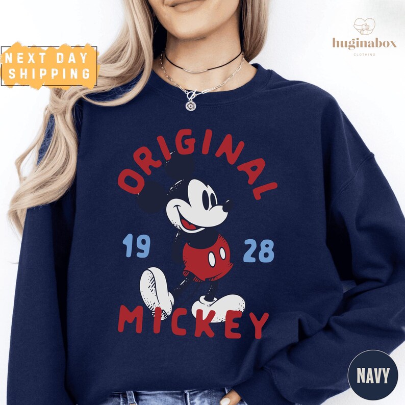 A woman wearing a navy blue sweatshirt with a graphic of Mickey Mouse printed on it.