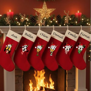 May include: Six red Christmas stockings with white tops hang above a fireplace. Each stocking features a different Disney character wearing a Santa hat and a name: Ava, Bella, Chloe, Daniel, Emily, and Fiona. A festive holiday scene.