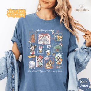 A woman wearing a blue t-shirt with a collage of Disney characters and a text overlay that says "The Most Magical Place on Earth" and "Next Day Shipping".