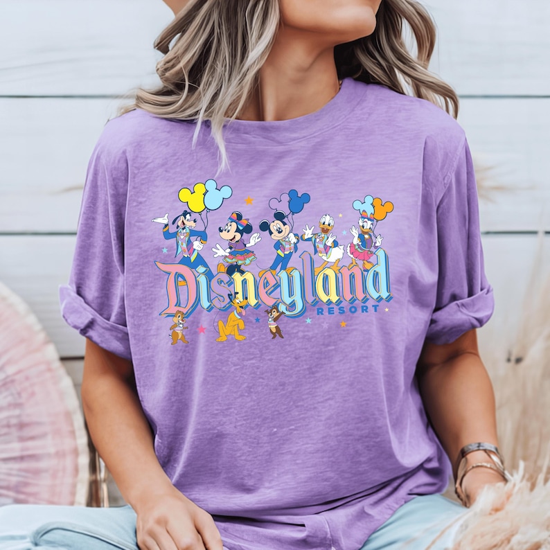 a woman wearing a purple disneyland shirt