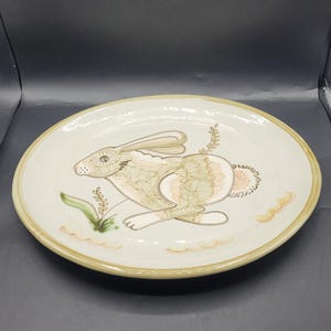 Puede incluir: Juego de tres tazas de cerámica color crema con un esmalte moteado. Cada taza presenta un diseño floral pintado a mano en tonos azules, verdes y amarillos. Las tazas tienen una forma simple y redondeada y un asa cómoda.