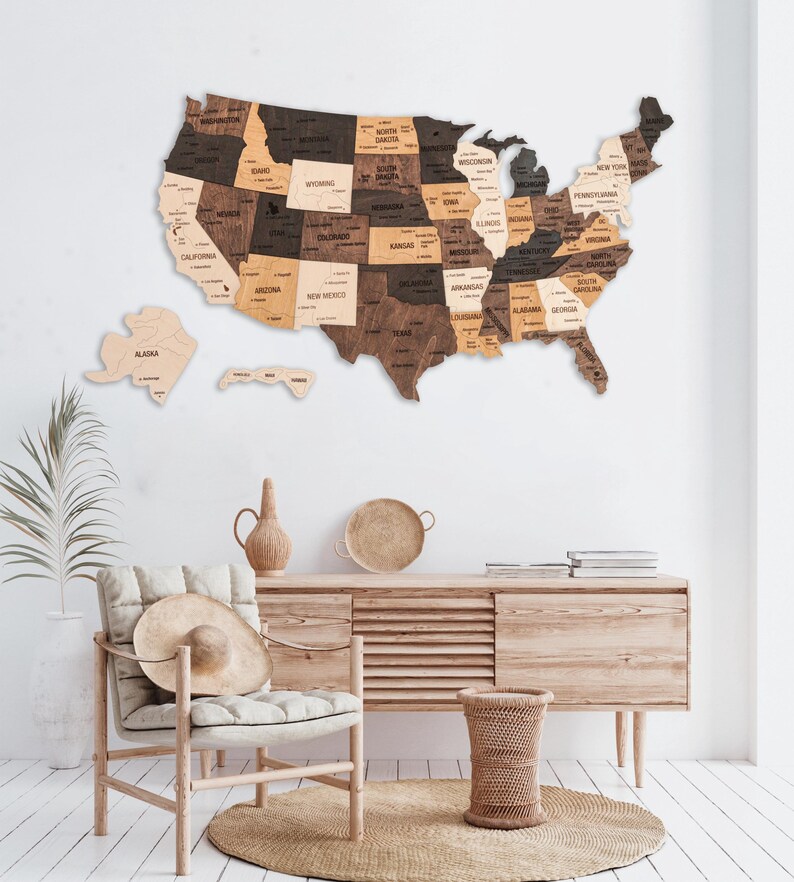 May include: A wooden map of the United States with each state outlined in a different shade of brown. The states are labeled with their names and major cities are marked with dots.